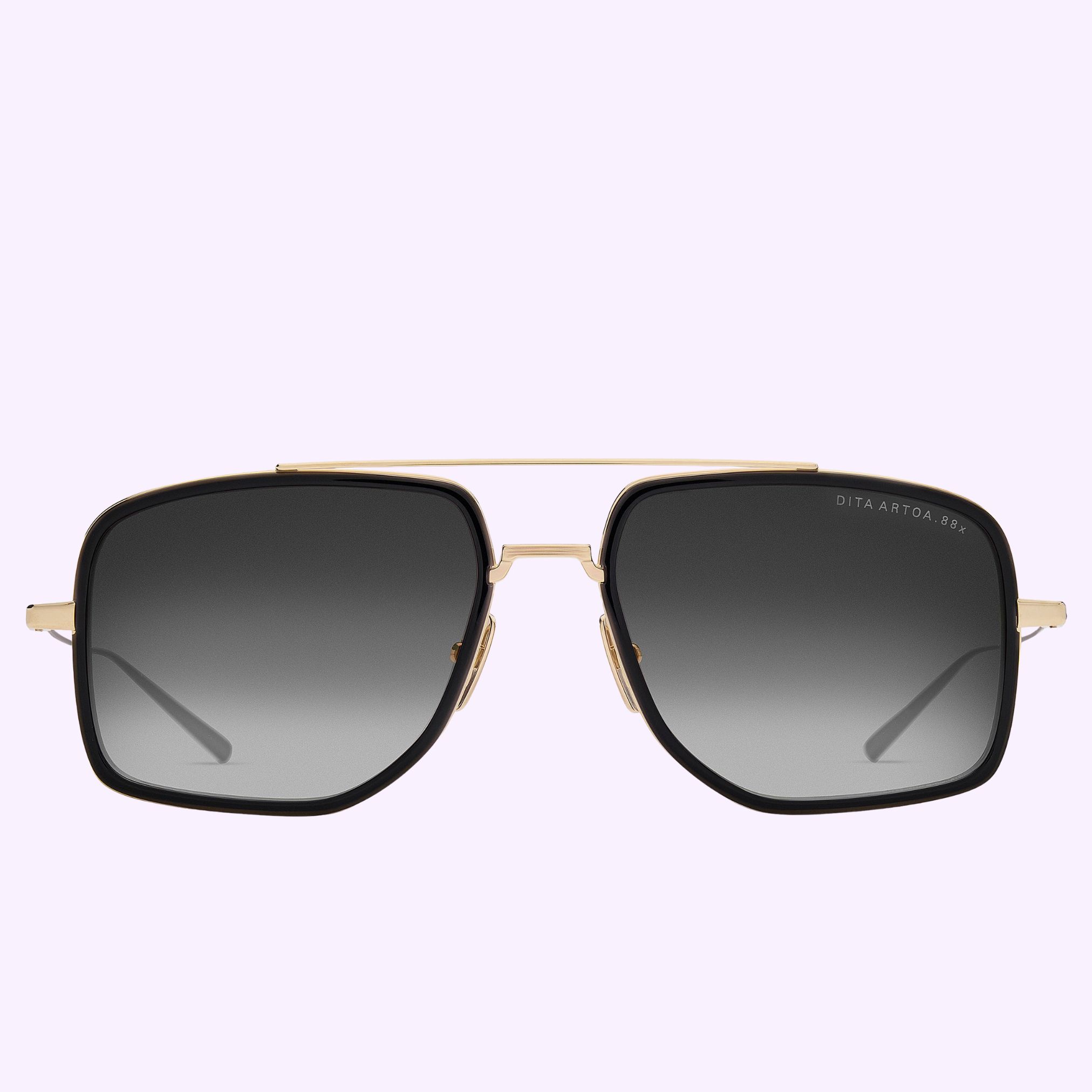 The Dita Sunglasses ARTOA.88x DTS471-A-02 by Dita Sunglasses feature an oversized navigator design with black gradient lenses, a gold metal frame, and a double bridge, shown against a pale lavender background.
