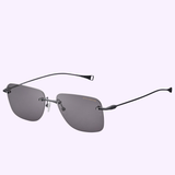The Dita Sunglasses LSA-119 DLS119-A-03RO feature a rimless design with rectangular gray polarized lenses and sleek black titanium frame arms, showcased against a light purple background.
