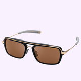 Introducing the Dita Sunglasses LSA-404 DLS404-56-01RO by Dita Sunglasses: These rectangular black and gold frames feature brown polarized lenses and a slender gold bridge elegantly arching above the frame, highlighting exquisite Japanese craftsmanship. The arms are finished with gray tips, set against a light purple background.