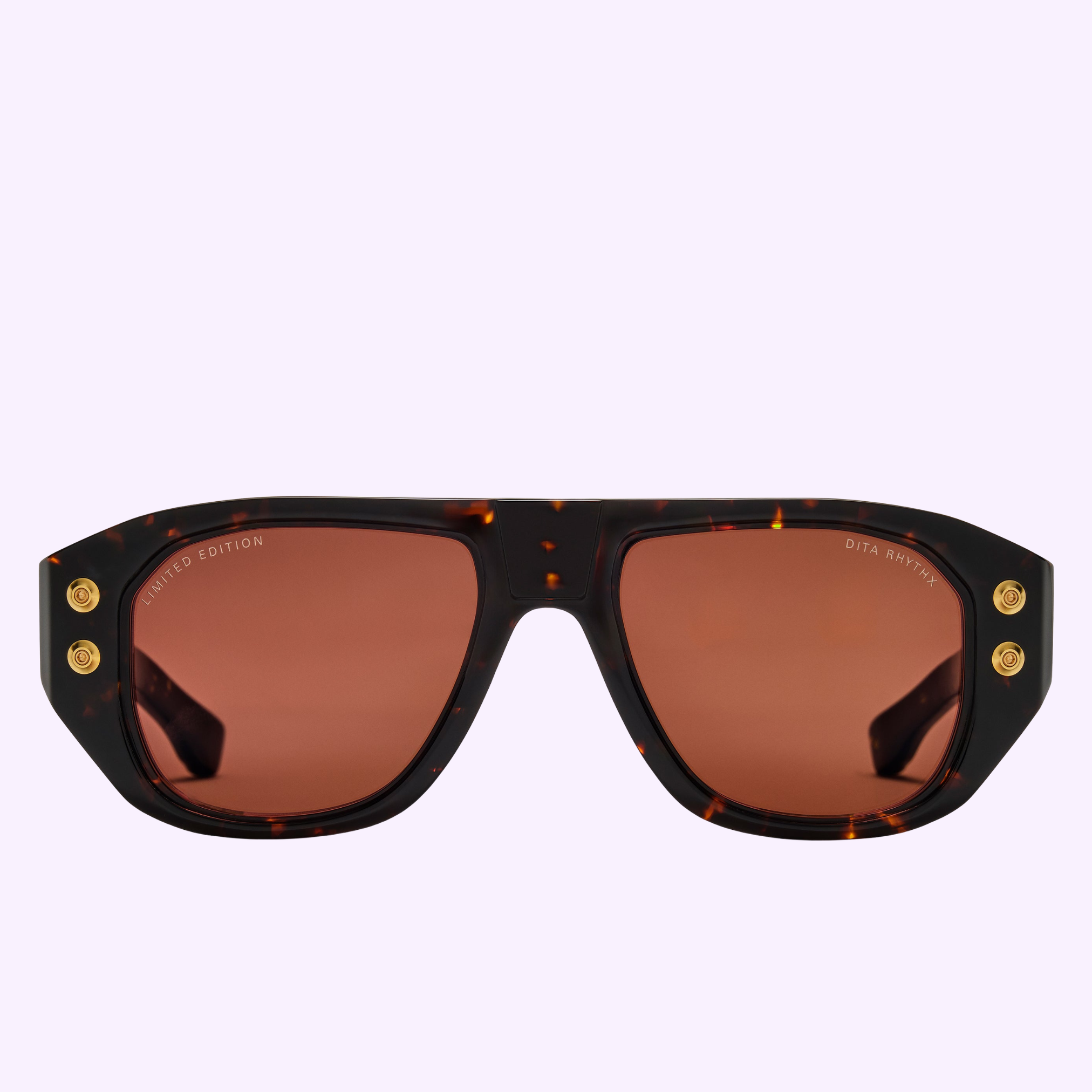 The Dita Sunglasses RHYTHX DTS741-A-03 Limited Edition features a sculptural navigator shape, brown rectangular lenses, and gold corner accents, presented against a light purple background.