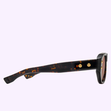 Side view of Dita Sunglasses RHYTHX DTS741-A-03 Limited Edition featuring a sculptural navigator shape, tortoiseshell frame, dark lenses, and gold temple accents against a light purple background.