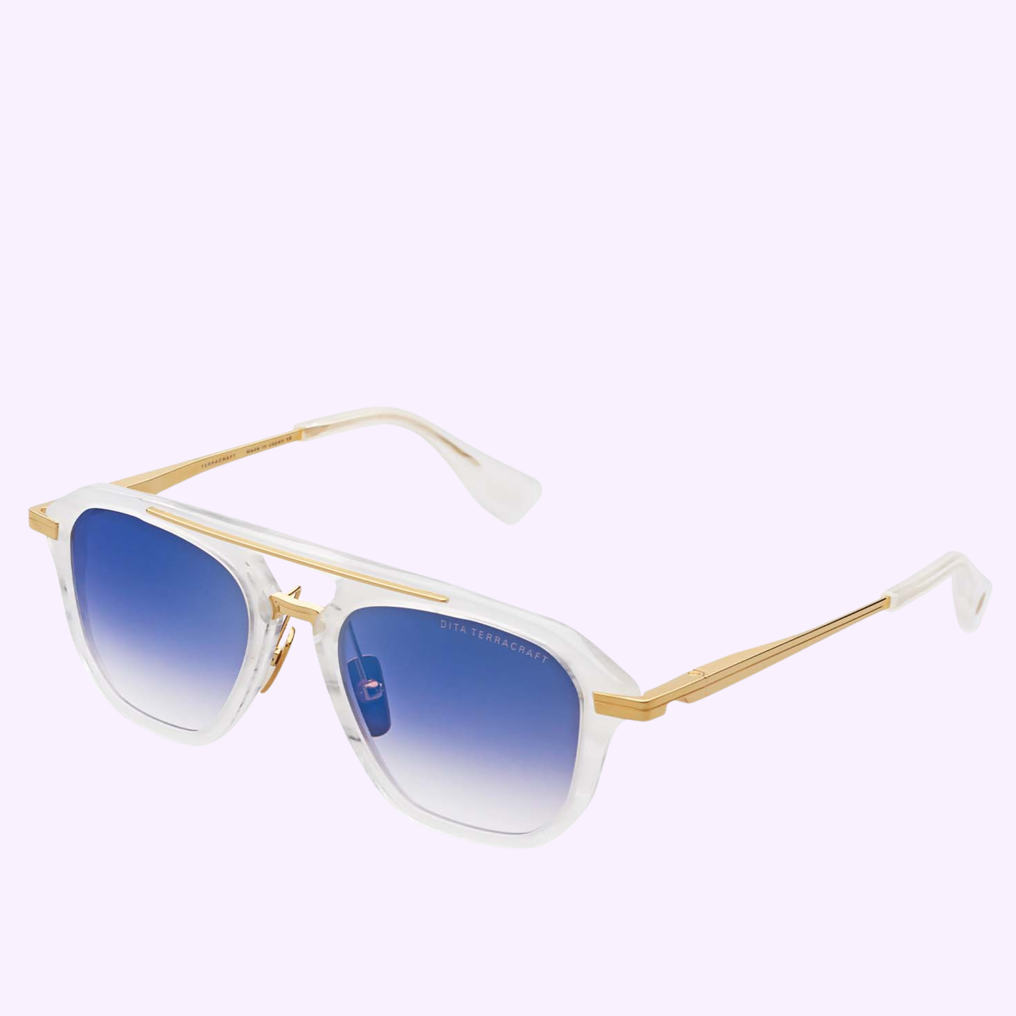 The Dita Sunglasses TERRACRAFT DTS416-A-02 feature square navigator shapes with translucent white frames, gold metal arms, and blue gradient lenses, displayed on a light purple background.