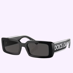 Dolce&Gabbana 0DG6187 501/8753 Sunglasses feature black rectangular frames with thick sides and dark lenses, adorned with the bold DOLCE & GABBANA logo in white on the arms. Displayed against a light background, these authentic Dolce&Gabbana sunglasses are the perfect accessory to elevate your everyday Miami style with a touch of luxury.