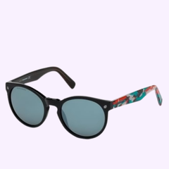 The Dsquared DQ0172 01C 53 unisex optical frame by Dsquared Sunglasses features round black frames with blue-tinted lenses and colorful, patterned arms. Set against a light purple background, this standout eyewear is inspired by iconic Dsquared2 designs and is available from an authorized Miami dealer.