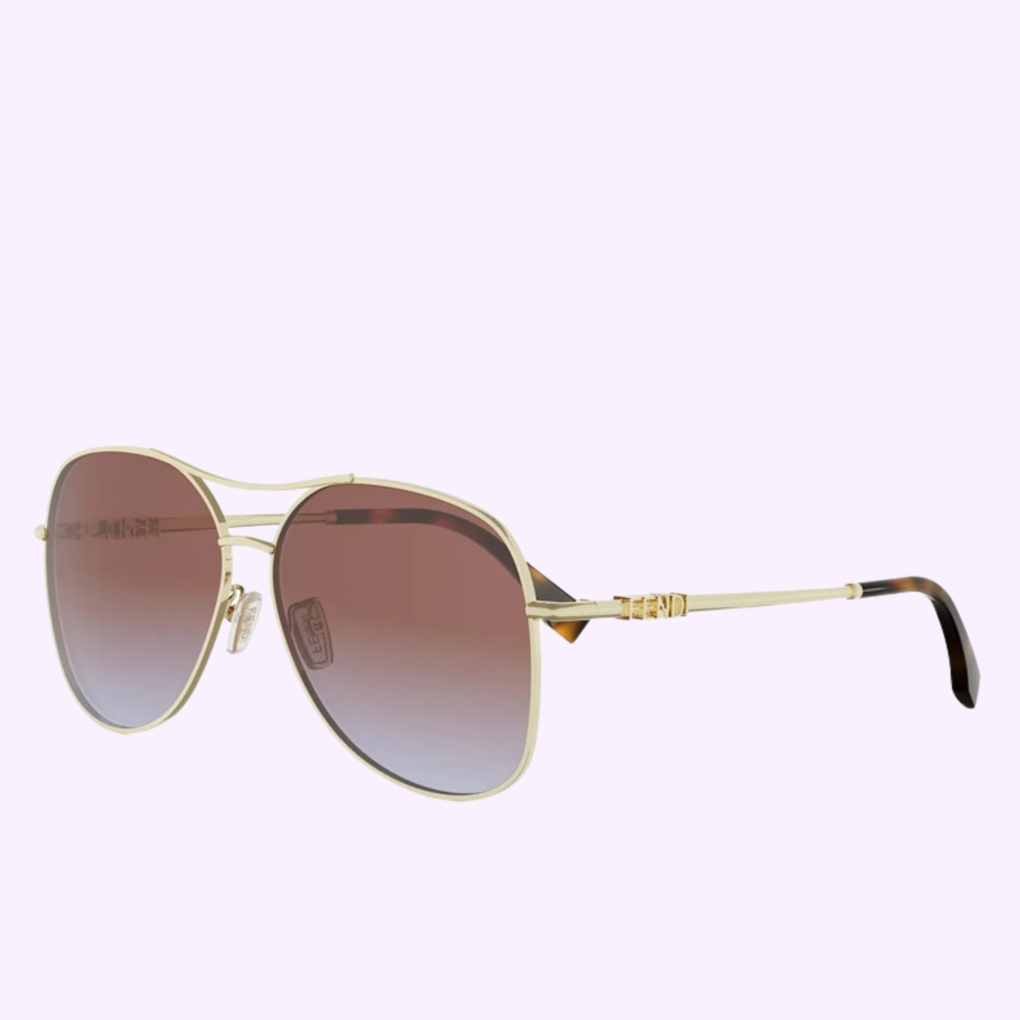 Fendi Sunglasses FE40200U 6130T WOMAN feature gold aviator frames, brown gradient lenses, a double bridge, and black-tipped thin metal arms, capturing elegant Fendi style against a light purple background.