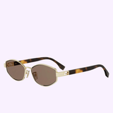 A pair of Fendi Sunglasses FE40216U 5630E with gold frames, brown tinted lenses, and tortoiseshell-patterned arms featuring a subtle Baguette logo on the temple, displayed on a light purple background.