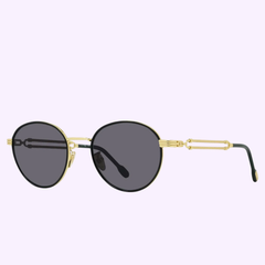 Fred FG40028U 01A 52 Force 10 Unisex Sunglasses by Fred Sunglasses feature black UV-protection lenses, gold metal frames, and decorative gold temples, displayed on a light purple background.