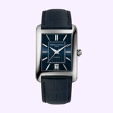 The Frederique Constant Watches Classic Carre Automatic Leather FC-303N4C26 features a minimalist rectangular design, blue leather strap, blue dial with silver indices and hands, date display at 6 o'clock, in a polished silver case on a light purple background.