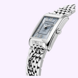 A stainless steel rectangular wristwatch with a metal link bracelet, deep blue dial, Roman numeral hour markers, and date display, showcased on a pale lavender background—this unisex Classics Carrée Automatic FC-303RLB4C6B from Frederique Constant embodies the brand’s signature timeless elegance.