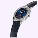 The Frederique Constant Classics Moneta Moonphase FC-206N3S6 is a luxury wristwatch featuring a blue dial with silver markers, an elegant moonphase subdial, and a dark blue leather strap—showcasing the exceptional Swiss craftsmanship of Frederique Constant. Displayed against a light purple background, this refined timepiece draws inspiration from the prestigious Classics Moneta Moonphase collection and highlights its signature moonphase complication.