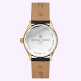 The back of a gold-tone Frederique Constant Classics Quartz Date FC-220CR5B5 watch case with a stainless steel backplate featuring engraved brand and model details, attached to a black leather strap.