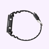A G-Shock Watches GA2100-1A1 2100 Series black digital wristwatch (UPC: 889232241630) is shown in a side profile view against a light purple background, highlighting its carbon core guard structure for superior durability.