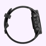 Side view of the Garmin Watches Forerunner® 570 - 42mm (010-02970-00) in black, featuring an AMOLED display, three right-side circular buttons, and a matching black strap with buckle against a light purple background.