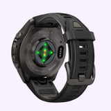 A black Garmin Watches fēnix® 9 Pro – 43mm (model 010-04335-15) GPS smartwatch by Garmin Watches is shown from the back, highlighting its charging sensor with four green lights and a silicone wristband.