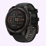 The Garmin Watches fēnix® 8 – 47 mm Solar (model 010-02906-10, UPC 753759339326) features a rugged design with a black silicone strap and a round display that shows fitness stats, date, time, and heart rate. Renowned for durability and advanced technology, this black smartwatch from Garmin Watches combines toughness with smart functionality.