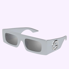 The Gucci Sunglass GG1646S-005 49 features silver rectangular thick frames, dark lenses, and an interlocking GG logo on the temples for a bold luxury look, shown on a light purple background. Brand: Gucci Sunglasses.