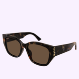 The Gucci Sunglasses GG2043SA-003 55 feature thick tortoiseshell frames and brown lenses, adorned with gold GUCCI lettering on the temples to embody true luxury fashion. This model is stylishly showcased against a light purple background.