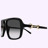 Close-up of Gucci Sunglasses GG2052S-007 55 by Gucci Sunglasses, showcasing black square frames with gradient gray lenses and a signature gold horsebit detail on the arms, set against a pale lavender background—a perfect embodiment of luxury fashion.