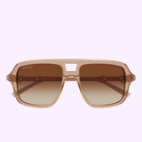 Front view of Gucci Sunglasses GG2052S-010 55 by Gucci Sunglasses, showcasing a transparent frame, brown gradient lenses, and a distinctive keyhole bridge—an iconic luxury accessory—photographed against a light purple background.