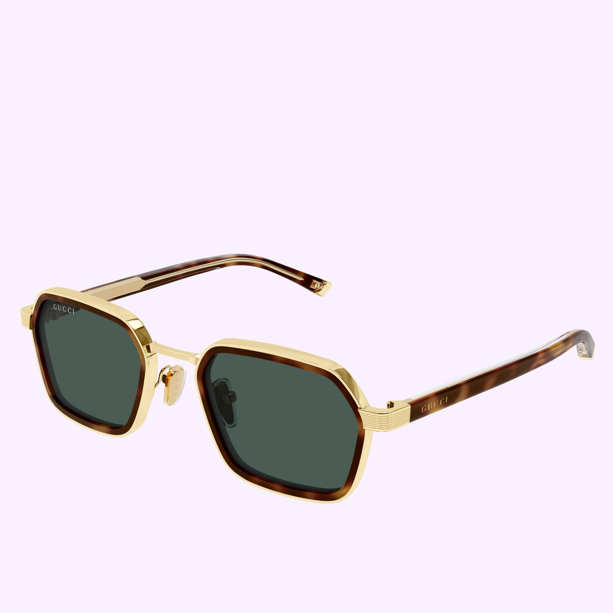 The Gucci Sunglasses GG2074S-003 51, featuring gold frames, dark green lenses, and tortoiseshell-patterned arms that embody contemporary eyewear style, are displayed on a light lavender background.