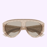 Gucci Sunglasses GG2128S-005 58 feature an oversized beige design with a transparent frame and light brown tinted lenses, adorned with the signature Gucci logo pattern across both the frame and lenses. Crafted for luxury fashion enthusiasts, these statement Gucci Sunglasses are showcased against a soft pastel purple background.