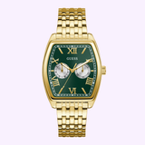 The Guess GW0975G2 Men's Gold Tone Multi-function watch by Guess Watches features a green rectangular face with gold Roman numerals, two subdials, and a gold metal link band, combining elegance and versatility against a light background.