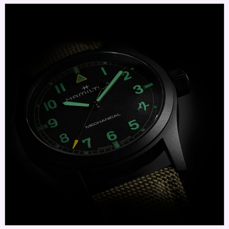 Angled view of the Hamilton H69469930 case and olive textile strap in low light