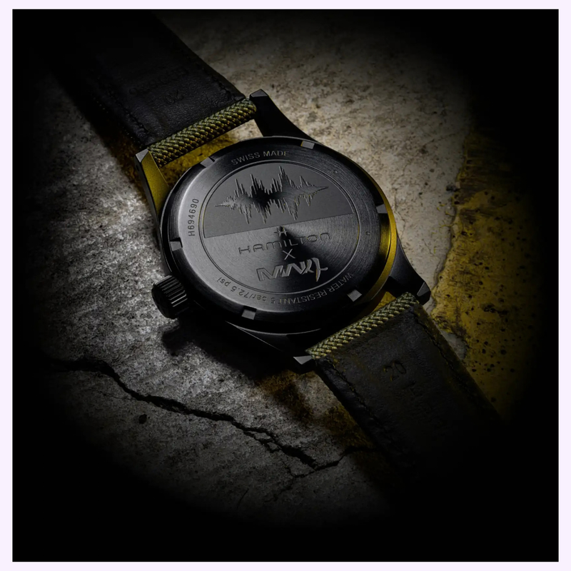 Hamilton H69469930 caseback resting on cracked concrete with yellow markings