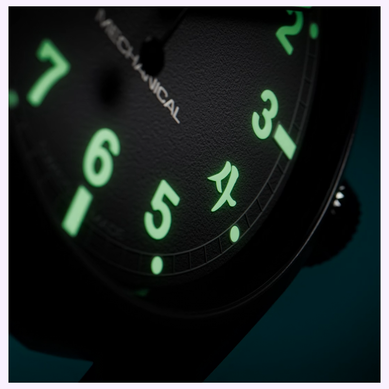 Close-up of the Hamilton H69469930 dial glowing numerals and yellow triangle at 12 o'clock in low light