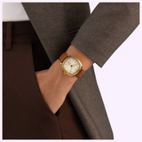 Gold cushion-shaped Hamilton Watches H36139520 American Classic Cushion Mechanical watch with a white dial and tan leather strap worn on a wrist.