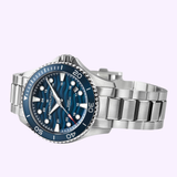 A silver stainless steel wristwatch, the Hamilton Watches H82425140 Khaki Navy Scuba Auto 40 mm, features a blue dial and bezel with silver hour markers, the Hamilton Watches logo, and a sleek metal link band—stylishly showcased against a light purple background.