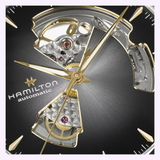 Close-up of the Hamilton Watches Jazzmaster Open Heart Auto 40 mm H32675181 by Hamilton Watches, featuring gold hands, a partially open heart design that reveals visible internal gears, and intricate mechanical details on the automatic dress watch face.