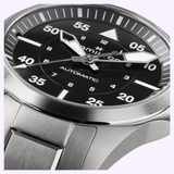 Close-up of the Hamilton Watches Khaki Aviation Pilot Auto H76215130, featuring a silver stainless steel case, metal band, black dial with bold white numerals, and large luminous hands—classic Hamilton Watches piloto 36mm design.