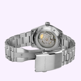 A Hamilton Watches Khaki Field Murph 38mm H70405140 wristwatch in stainless steel, featuring an open clasp and a transparent case back revealing its automatic movement, is displayed against a light purple background. The blue-to-black dial reflects the iconic interstellar design, seamlessly blending style with cinematic heritage.
