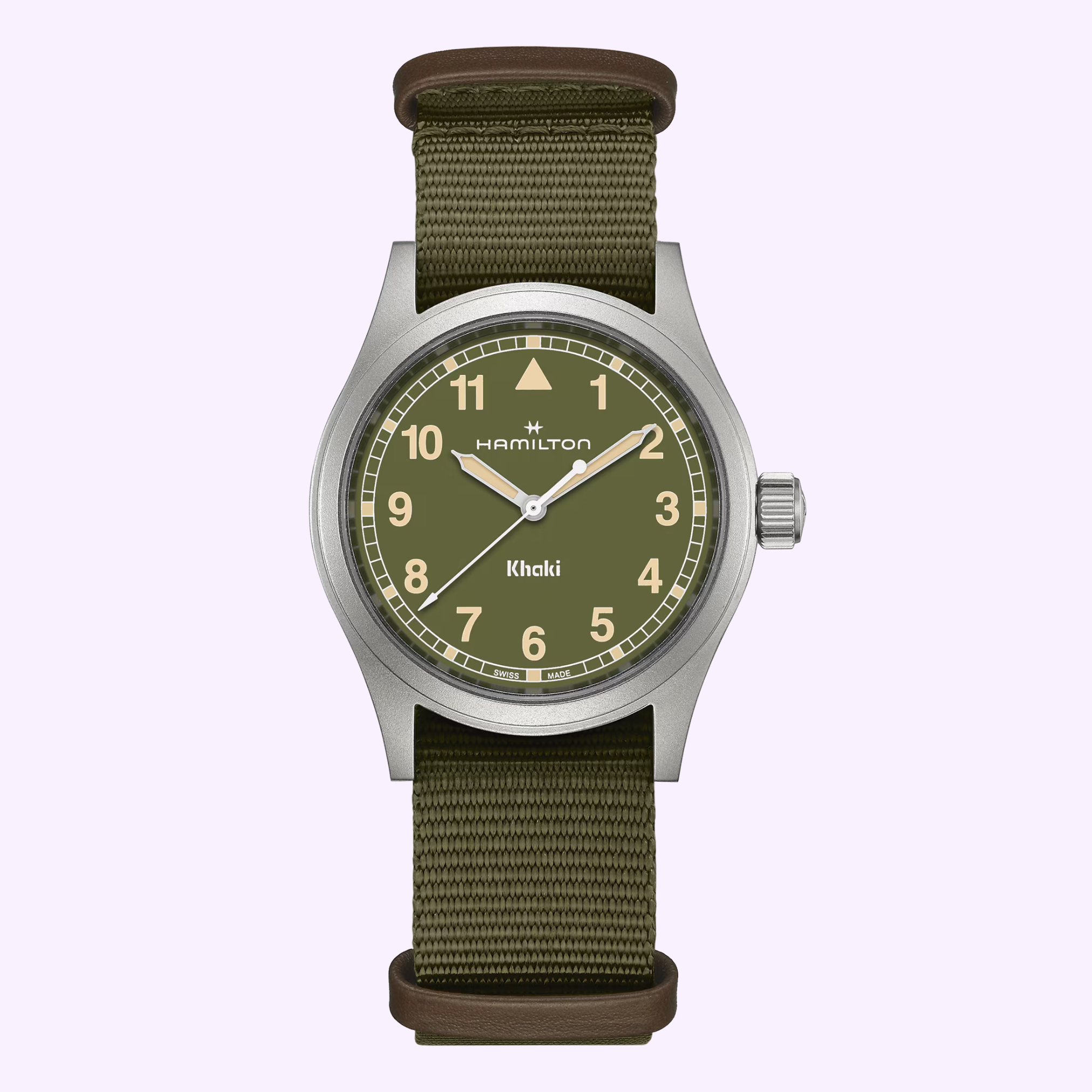 The Hamilton Watches Khaki Field Quartz 38mm H69401960 features a khaki green dial, beige numerals, and an olive fabric strap with brown leather accents, shown against a light purple background.