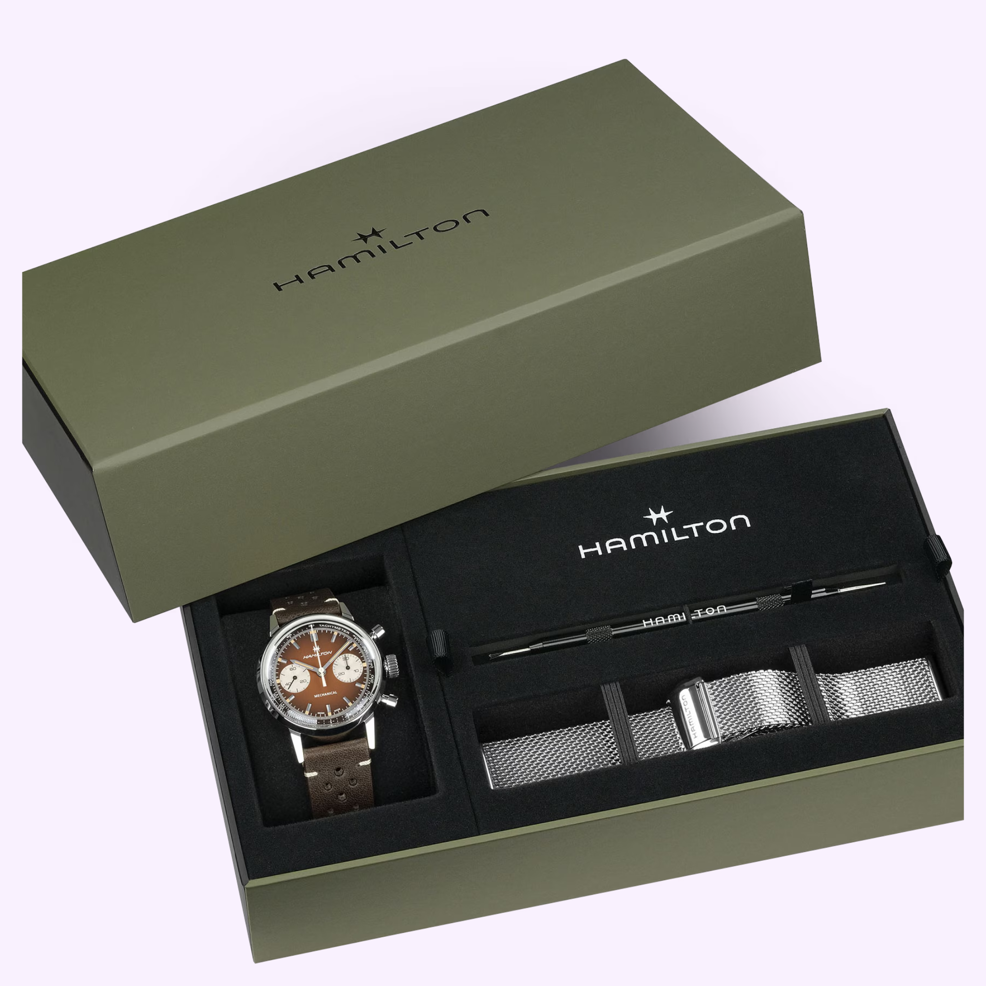 A green Hamilton box houses the American Classic Intra-matic Chronograph H38429861 with a brown strap, a silver mesh strap, and a strap-change tool—all elegantly arranged by Hamilton Watches.