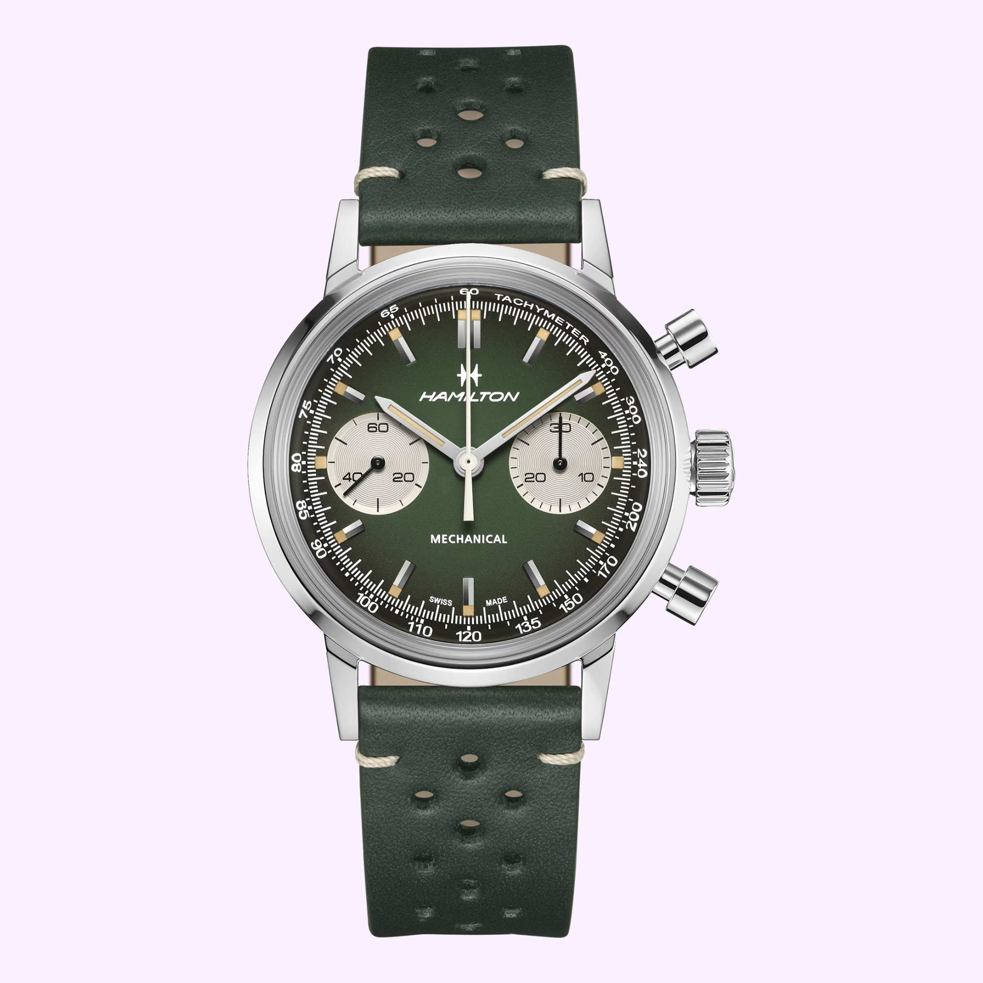 The Hamilton Watches American Classic Intra-matic Chronograph H38429861 features a green dial, two subdials, and stainless steel case with a dark green perforated leather strap, set against a light lavender background. A true American classic.