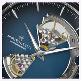 Close-up of the Hamilton Watches Jazzmaster Open Heart Auto H32675140, featuring a blue dial with exposed gears and inner mechanisms visible through open sections, plus silver hour and minute hands.
