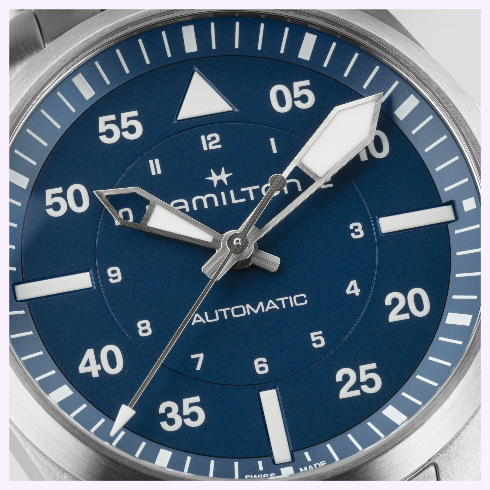Close-up of a Hamilton Watches Khaki Aviation Pilot Auto 39mm H76305140, featuring a blue dial, bold white hands, Arabic numerals, and white minute markers. The watch shows the time as approximately 8:06:21.