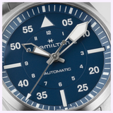 Close-up of a Hamilton Watches Khaki Aviation Pilot Auto 39mm H76305140, featuring a blue dial, bold white hands, Arabic numerals, and white minute markers. The watch shows the time as approximately 8:06:21.
