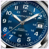 Close-up of a blue Hamilton Watches Khaki Field Auto 38 mm H70455540 dial showing the time as 8:10:37, with the date window displaying the number 8. The watch features white numerals and a stainless steel case.