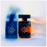 Two perfume bottles stand side by side: the left, blue with Wild Rush, and the right, dark with INITIO Parfums Prives SUGAR BLAST EDP 3.0 Oz Unisex Perfume by Initio Perfumes. Blue and orange motion blur surrounds each bottle respectively.