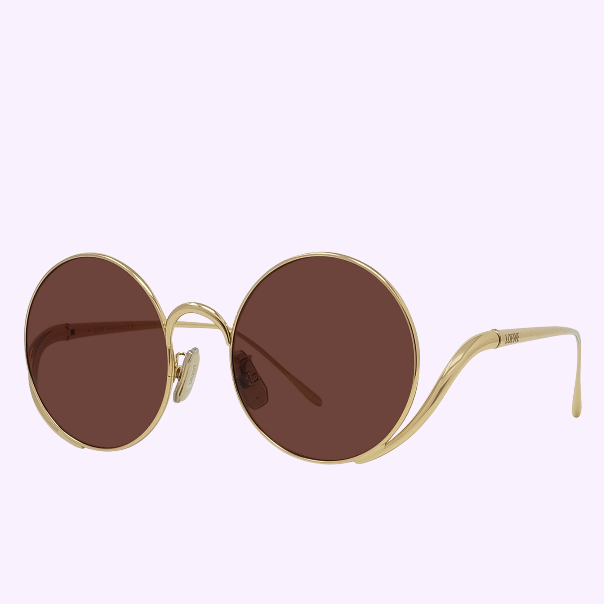 LOEWE Sunglasses LW40187U 5030S by Loewe Sunglasses with round gold metal frames, dark brown tinted lenses, and subtle metal stitches, showcased on a light purple background.