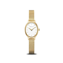 The Bering Watches Classic 11020-334 women's gold watch features a white oval face, minimal gold hour markers and hands, and a Milanese strap, shown against a plain white background. Brand: Bering Watches.