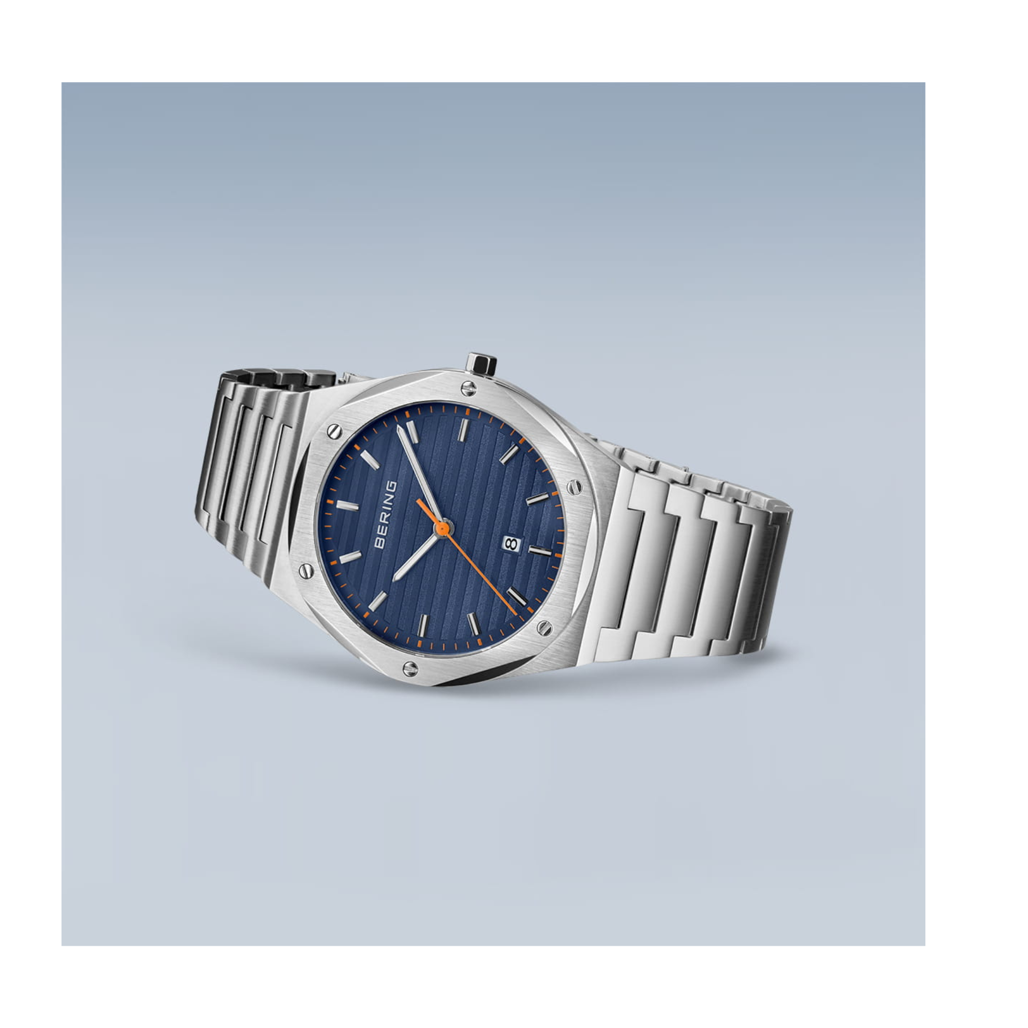 The Bering Watches Classic 19842-702 by Bering Watches is a silver women’s watch with a blue textured face, orange hands, date display, and a sleek Milanese strap, shown in an angled view on a light blue gradient background.