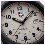 A close-up of the 43mm Luminox Watches Atacama Field XL.1971.SET shows 1:06:36 on its beige textured dial with bold numbers, date at 31, and “100 METERS” and “SWISS MADE” markings in a rugged CARBONOX case.