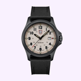 The Luminox Watches Atacama Field XL.1971.SET features a 43 mm CARBONOX case, beige dial with black numerals and hands, date window at 3 o’clock, and black textured strap, shown against a light purple background.