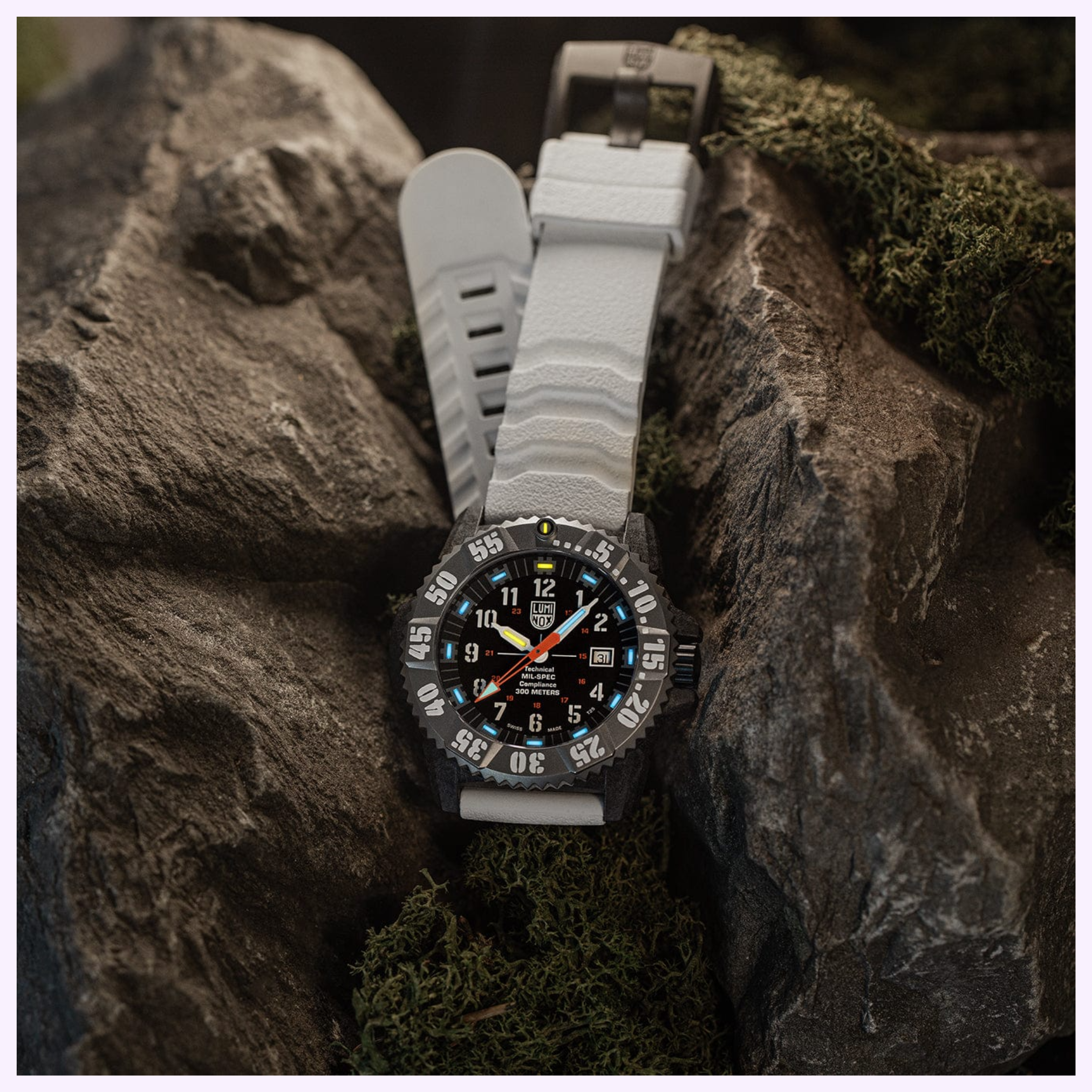 The Luminox Watches MIL-SPEC XL.3359.SET by Luminox Watches, featuring a black dial and white strap, sits on a rocky surface with green moss. Bold numerals, luminous hands, and 300m water resistance ensure exceptional reliability anywhere.