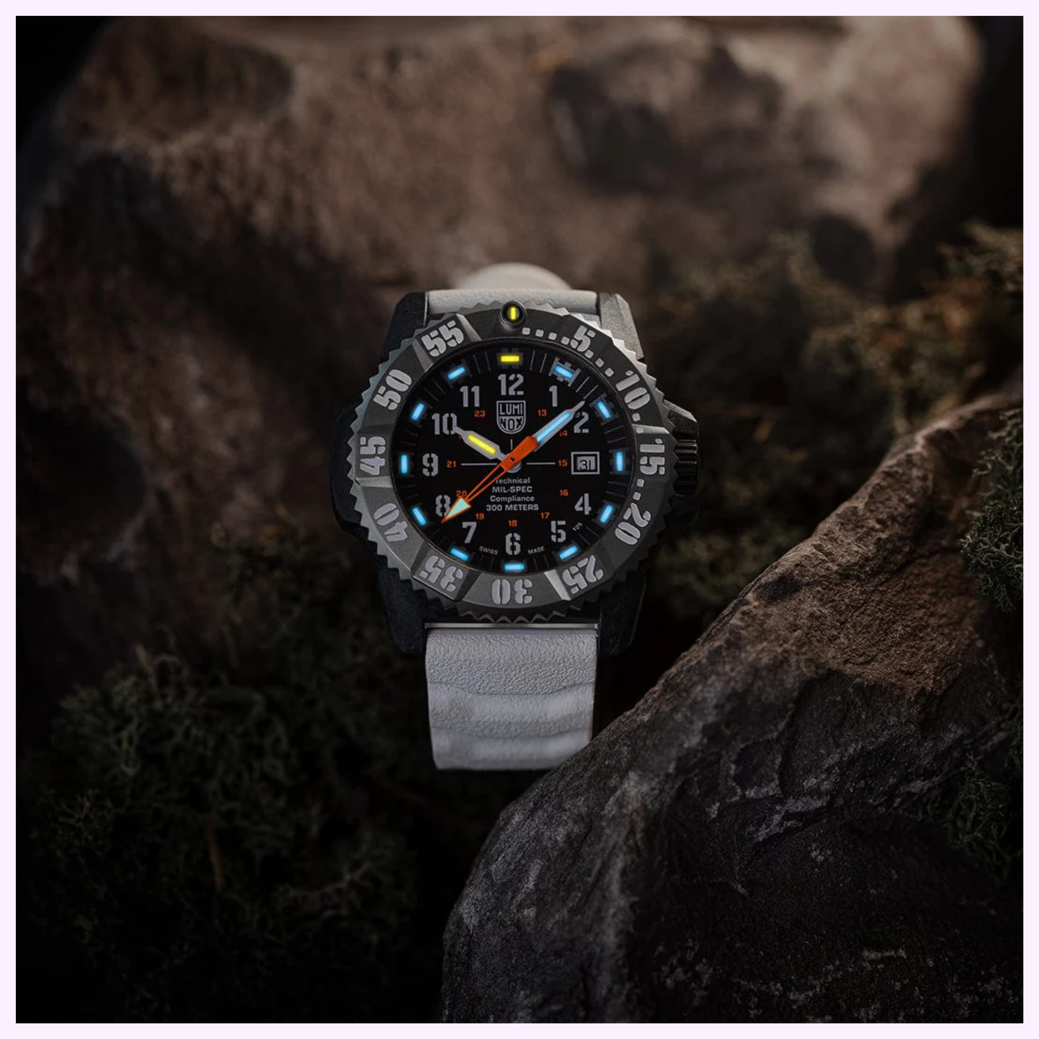 The Luminox Watches MIL-SPEC XL.3359.SET, a rugged black wristwatch with a grey strap, rests on rocks among moss. Its glowing white, blue, and orange dial details highlight the 300-meter water resistance by Luminox Watches.