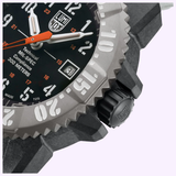 Close-up of the Luminox Watches MIL-SPEC XL.3359.SET by Luminox Watches, featuring a black dial with white numerals, orange hands, date at 3 o’clock, gray textured bezel, right-side crown, and 300m water resistance for a rugged style.